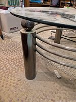Close-up of metal leg and glass top attachment