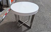 full view of round white side table showing chrome X-base