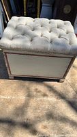 Bench showing cream painted body, red trim, tufted top