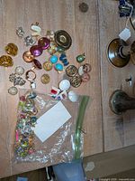Overview of assorted clip-on earrings and bagged extras on tabletop