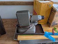 Left side view of gray Vivitar projector with cord and tray