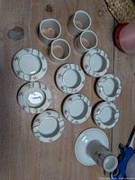 Full lot showing 4 napkin rings, 8 ashtrays, 1 candlestick on table