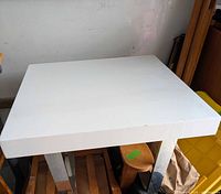 Overall view of the white square table showing top and legs