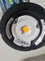 Front of downlight showing white trim and LED COB