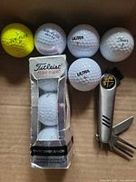 Assortment of used golf balls, Titleist box, multi-tool