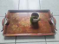 Top view of wooden serving tray with floral motif and potted plant