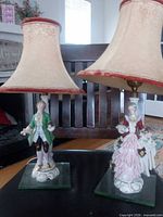 Pair of porcelain figurine lamps with shades