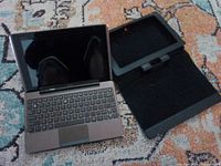 Open Asus tablet attached to keyboard dock alongside separate protective case