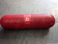 Red Beats Pill Bluetooth speaker on surface