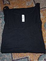 Folded black Bella sleeveless tank top with visible size M tag