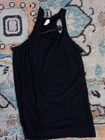 Full view of black racerback tank top laid flat