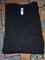 Folded black Bella+Canvas t-shirt showing neck tag