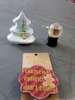 All three holiday items grouped: acrylic tree snow globe, glass snow globe, magnetic chip clip