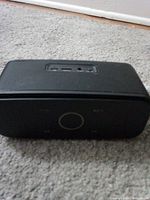 Front angled view of speaker showing grille and compact form