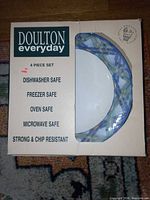 Front of boxed Royal Doulton Everyday 4-piece dish set showing pattern and safety features.