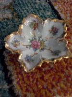 Top view of leaf porcelain dish showing floral design and gold edging