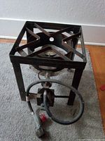 Front view of square steel stand showing burner head and hose