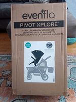 Front of sealed carton showing Evenflo Pivot Xplore stroller wagon image and product name
