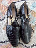 Top view of pair showing crocodile-embossed uppers and T-strap design