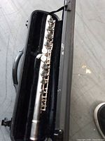 Flute inside open black molded case showing keys and body