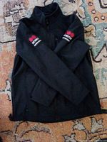 Front view of black Galls security softshell jacket showing embroidered logos and size