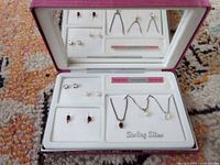 Full jewellery set in open box showing necklaces and earrings