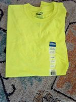 Folded neon yellow Gildan T-shirt with size and brand tags visible
