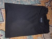 Folded black Gildan T-shirt displaying brand tag
