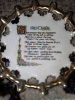 Front view of gold-edged openwork plate showing entire poem and rim detail