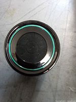 Front view of round black Haissky Bluetooth shower speaker showing control buttons and teal accent