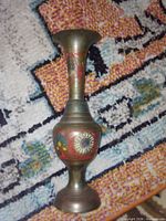Full view of brass vase with colored floral engravings