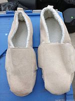 Pair of beige house slippers on blue bin