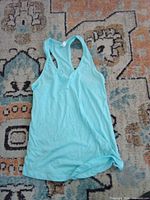 Front view of aqua racerback tank top laid flat