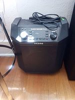 Front view of Ion Block Rocker Plus speaker with control panel, coiled power cord on top