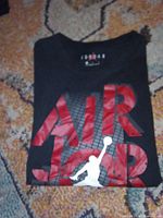 Folded black Air Jordan T-shirt showing front graphic and collar branding