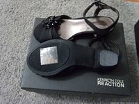 Top and sole view of both sandals on box