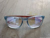 Front view of children’s eyeglasses showing blue translucent frame and red temples
