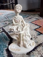 Front view of porcelain ballerina figurine on patterned rug