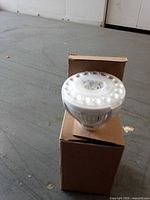 White LED bulb standing on its box
