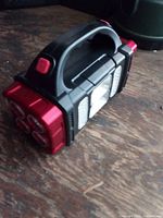 Overall view of LED rechargeable flashlight showing handle, front LED array, side panels