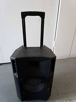 Front view of Ion portable speaker showing grille, woofer, telescoping handle