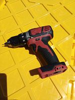 Left side view of Milwaukee M18 cordless drill/driver on yellow surface