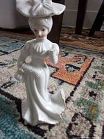 full view of white glass lady figurine standing on rug