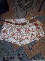 Front view of Mossimo floral shorts showing pattern, belt, size tag, and original tags