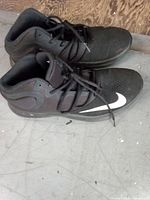 Top and side view of both black Nike Air Max shoes showing white swoosh and overall condition