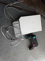 Wii console, power supply and Joy-Con grip with controllers on floor