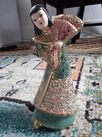 Front view of ceramic figurine showing fan, robe details, colours