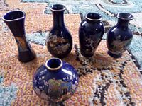 Five cobalt blue miniature vases arranged on rug