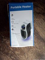 Front of sealed retail box showing portable heater specifications