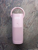 Front view of the blush pink Pure Enrichment PureZone Mini portable air purifier showing handle, power button, LED and vented lower half